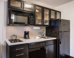 Sonesta Simply Suites Silicon Valley - Santa Clara day room kitchen, furnished with oven, hob, microwave, and fridge freezer.