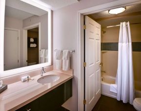 Sonesta ES Suites San Jose Airport guest room bathroom, featuring sink, mirror, bath, shower, and lavatory.