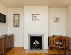 Day use room with TV, workspace, and chimney at The Farrington Inn.