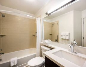 Sonesta Simply Suites Boston Braintree guest bathroom, featuring bath with a shower, plus sink, wide mirror, and lavatory.