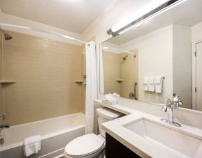 Sonesta Simply Suites Arlington guest bathroom, including bath with a shower, sink, and lavatory.