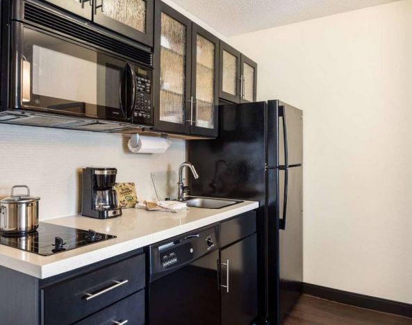 Sonesta Simply Suites Baltimore BWI Airport day room kitchen, fully equipped with fridge freezer, and hob, oven, and microwave.