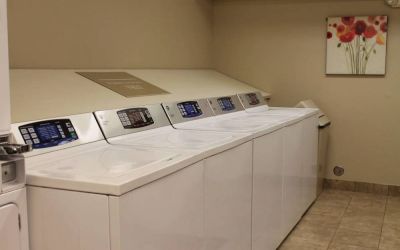The hotel’s laundry room has numerous machines for guests to use, and art on the wall.