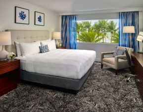 Double bed guest room in Sonesta Fort Lauderdale Beach, furnished with armchair plus workspace desk and chair.