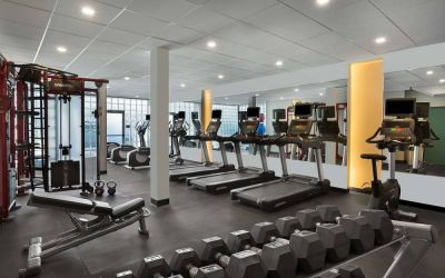 The hotel fitness center has rows of free weights, both dumbbells and kettlebells, and an assortment of exercise machines.