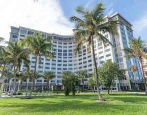 Sonesta Fort Lauderdale Beach’s exterior has extensive greenery, including numerous palm trees.