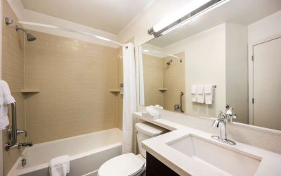 Guest bathroom with shower and bath at Sonesta Simply Suites Detroit Warren.