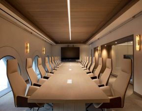 Meeting room in The Clift Royal Sonesta, featuring long table with seating for over a dozen attendees, cozy atmosphere, and large, wall-mounted TV.