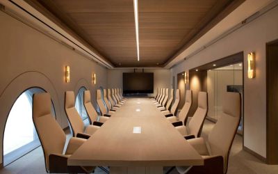 Meeting room in The Clift Royal Sonesta, featuring long table with seating for over a dozen attendees, cozy atmosphere, and large, wall-mounted TV.