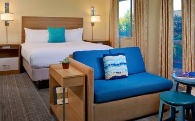 Double bed guest room in Sonesta ES Suites Flagstaff, including large windows and a sofa.