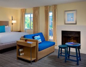Sonesta ES Suites Flagstaff double bed guest room, featuring sofa, stool, coffee table, and fireplace.