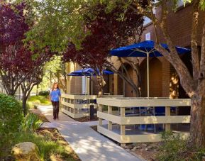 The hotel’s exterior has numerous trees and shaded table and chairs where guest can relax or co-work.