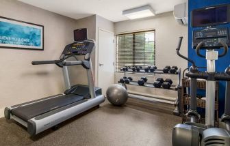 Sonesta ES Suites Charlotte Arrowood’s fitness center is equipped with rows of free weights and various exercise machines.