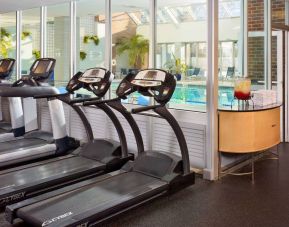 The hotel fitness center has numerous exercise machines and is adjacent to the indoor pool.