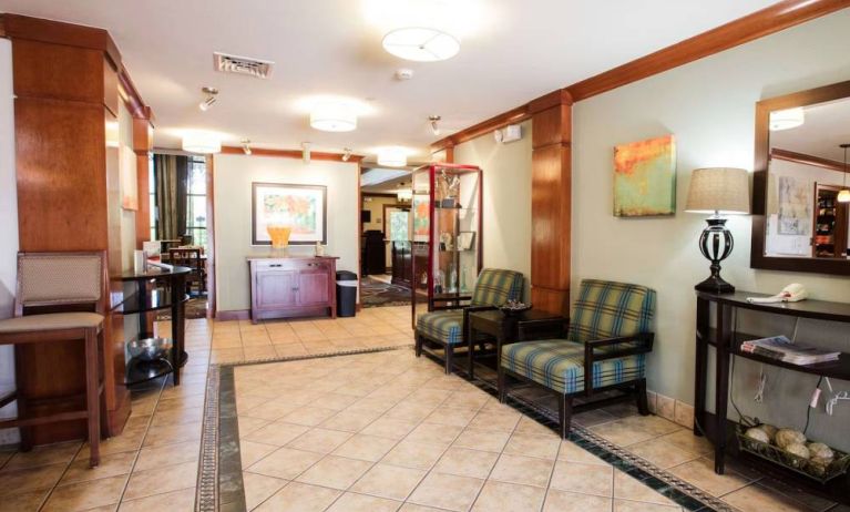 Sonesta ES Suites Austin The Domain Area’s lobby has a pair of armchairs, a coffee table, and art on the walls.