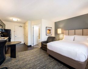 Sonesta Simply Suites Pittsburgh Airport double bed guest room, including armchair and a kitchen area.