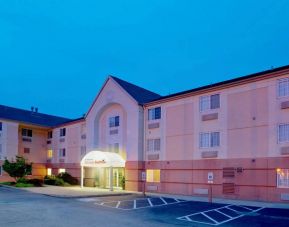 Sonesta Simply Suites Pittsburgh Airport’s exterior includes a covered entrance, pleasant greenery, and parking spaces.