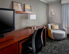 Sonesta Select Tinton Falls Eatontown guest room workspace, with desk, chair, and lamp, and TV.