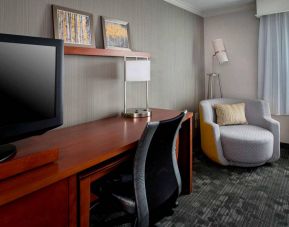 Sonesta Select Tinton Falls Eatontown guest room workspace, with desk, chair, and lamp, and TV.
