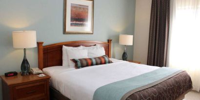 Sonesta ES Suites Portland Vancouver 41st Street double bed guest room, featuring art on the wall and a large window.