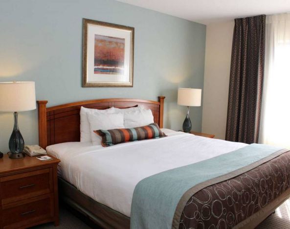 Sonesta ES Suites Portland Vancouver 41st Street double bed guest room, featuring art on the wall and a large window.