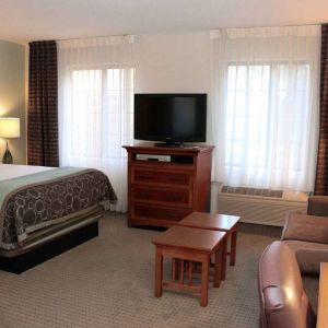 Double bed guest room in Sonesta ES Suites Portland Vancouver 41st Street, including lounge area with sofa, TV, and coffee tables.