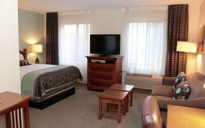 Double bed guest room in Sonesta ES Suites Portland Vancouver 41st Street, including lounge area with sofa, TV, and coffee tables.