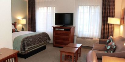 Double bed guest room in Sonesta ES Suites Portland Vancouver 41st Street, including lounge area with sofa, TV, and coffee tables.