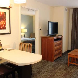 Sonesta ES Suites Portland Vancouver 41st Street guest room, furnished with double bed, desk and chairs, and a widescreen TV.