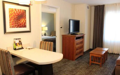 Sonesta ES Suites Portland Vancouver 41st Street guest room, furnished with double bed, desk and chairs, and a widescreen TV.