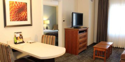 Sonesta ES Suites Portland Vancouver 41st Street guest room, furnished with double bed, desk and chairs, and a widescreen TV.