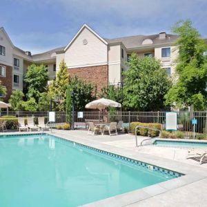 Sonesta ES Suites Portland Vancouver 41st Street’s outdoor pool has a nearby hot tub, with sun loungers, and shaded tables and chairs in the vicinity.