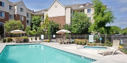 Sonesta ES Suites Portland Vancouver 41st Street’s outdoor pool has a nearby hot tub, with sun loungers, and shaded tables and chairs in the vicinity.