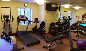 The fitness center of Sonesta ES Suites Portland Vancouver 41st Street has rows of free weights, a wall-mounted TV, and a variety of xercise machines.