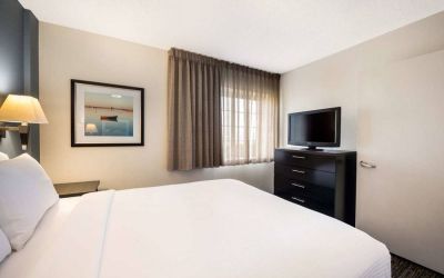 Double bed guest room in Sonesta Simply Suites Salt Lake City Airport, with TV and window.
