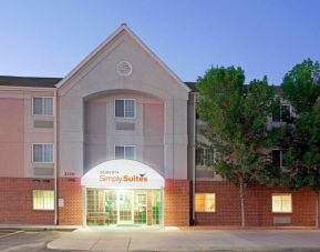 The hotel’s exterior has parking for guests on one side of the covered entrance, and trees to the other side.