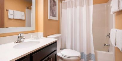 Sonesta Simply Suites Seattle Renton guest bathroom, furnished with bath and shower, lavatory, and mirror and sink.