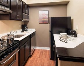 Sonesta Simply Suites Seattle Renton guest room kitchen, furnished with oven, hob, microwave, and fridge-freezer.