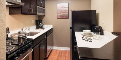 Sonesta Simply Suites Seattle Renton guest room kitchen, furnished with oven, hob, microwave, and fridge-freezer.