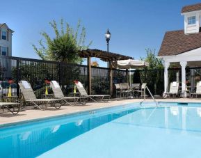 Sonesta Simply Suites Seattle Renton’s outdoor pool is fenced off and has both sun loungers and chairs by the side.