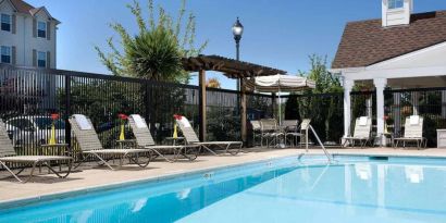 Sonesta Simply Suites Seattle Renton’s outdoor pool is fenced off and has both sun loungers and chairs by the side.