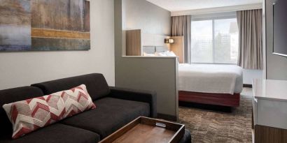 Sonesta Select Seattle Renton double bed guest room, featuring TV, window, and sofa.