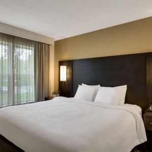 Double bed guest room in Sonesta ES Suites Parsippany Morris Plains, with bedside lighting and a large window.