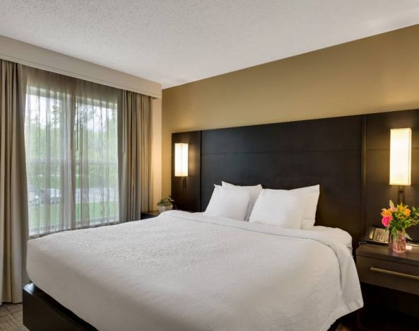 Double bed guest room in Sonesta ES Suites Parsippany Morris Plains, with bedside lighting and a large window.