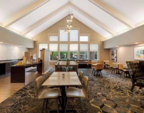 The hotel’s breakfast area is spacious and has large windows, with tables varying from two seats to eight, and art on the wall.