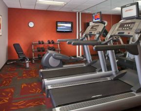 Sonesta ES Suites Birmingham Homewood’s fitness center features treadmills, an elliptical, bench, and rows of free weights, plus a TV.