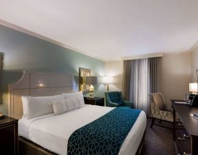 Double bed guest room in Royal Sonesta New Orleans, featuring television, armchair, and a workspace desk and chair.