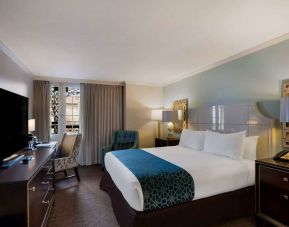 Royal Sonesta New Orleans double bed guest room, furnished with armchairs, desk, and a television.