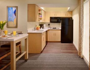 Sonesta ES Suites Atlanta - Perimeter Center North guest room kitchen, featuring fridge-freezer, microwave, hob, and oven.