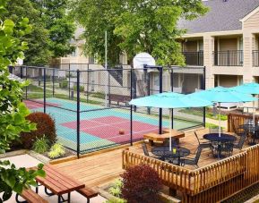 Sonesta ES Suites Atlanta - Perimeter Center North’s terrace is next to the basketball court, and furnished with shaded tables and chairs.